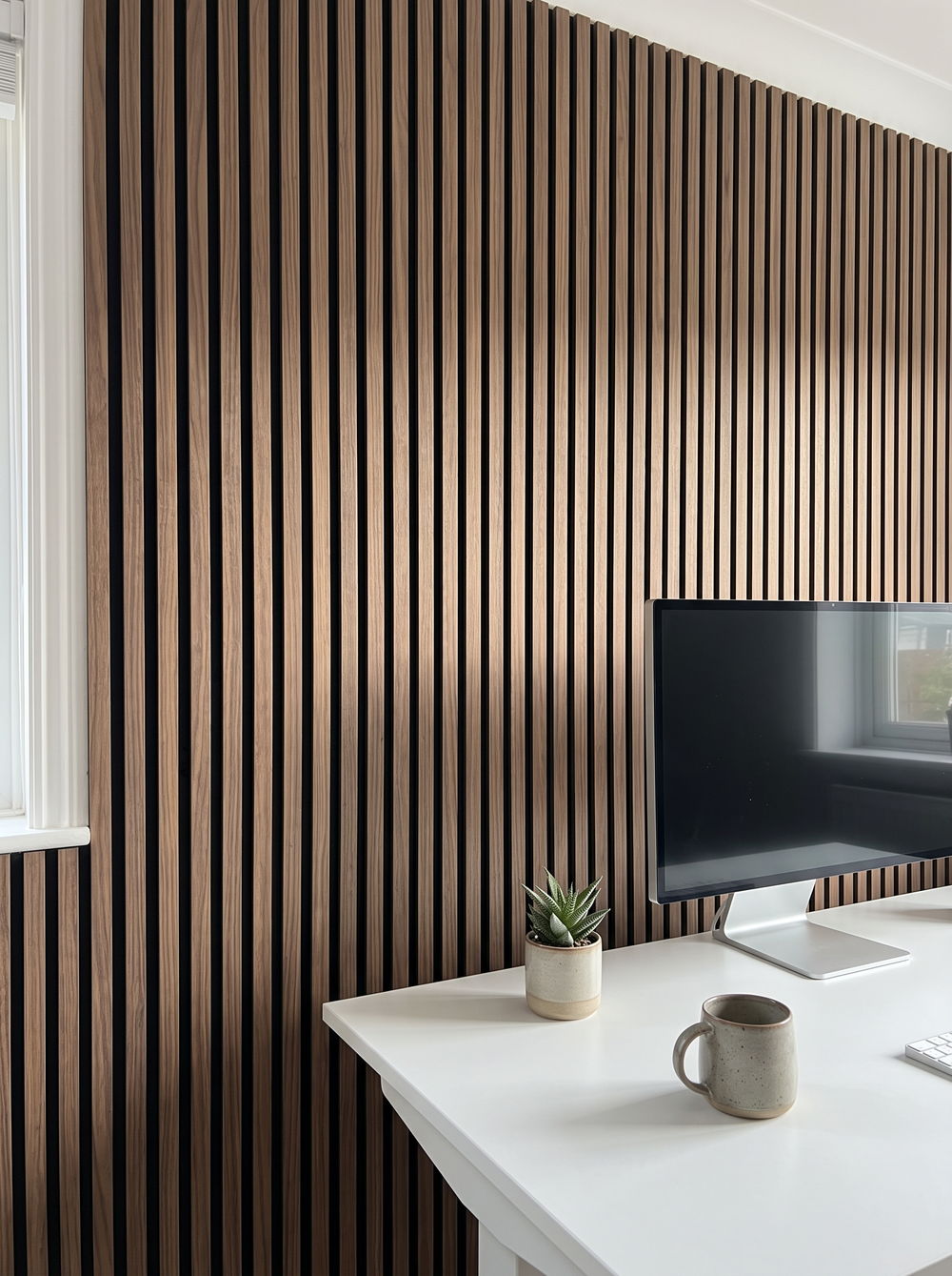 A walnut acoustic wood slat wall behind a sofa